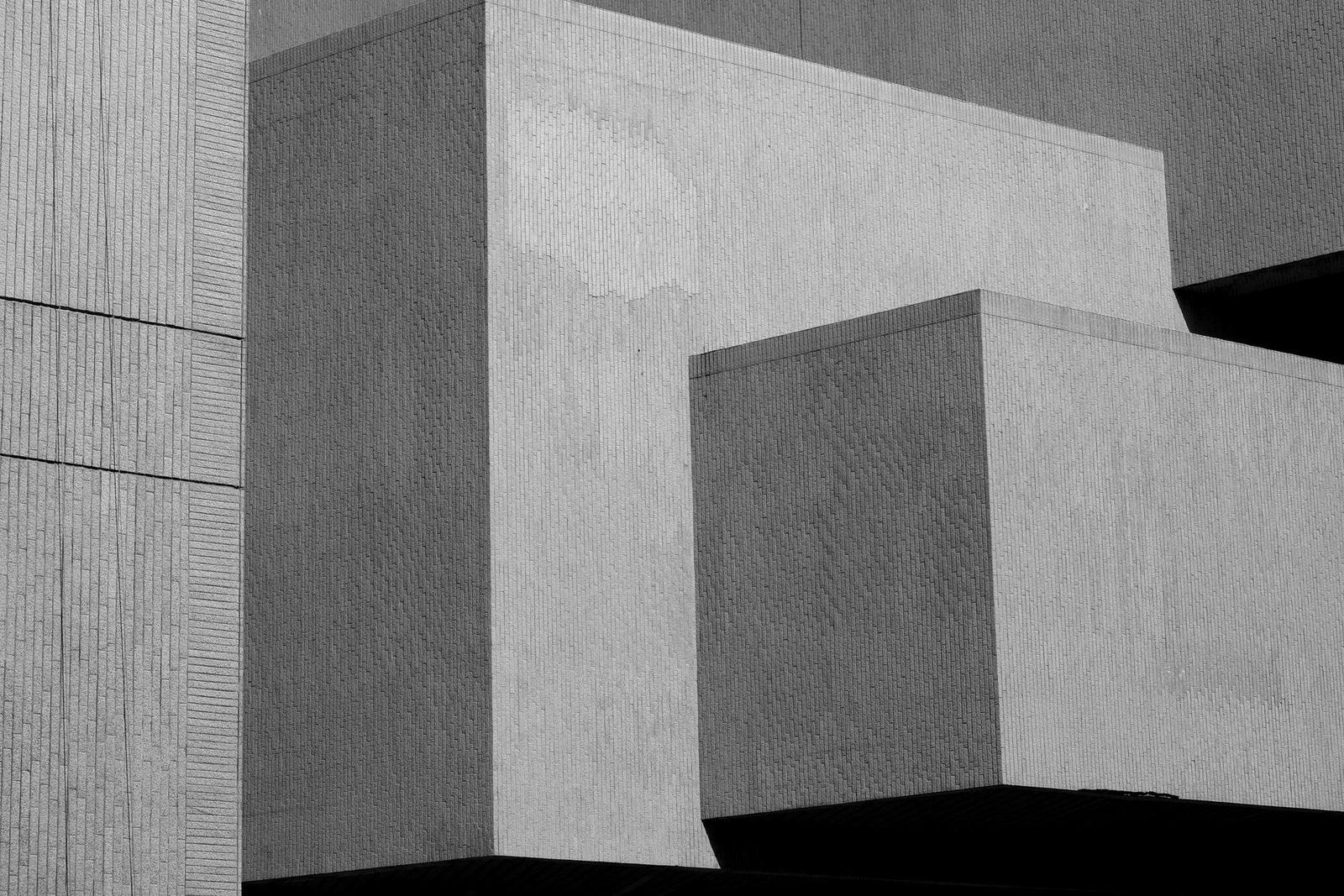 打ち放しコンクリートの建物を見上げた白黒写真